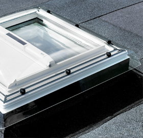 A flat roof window with a partially open blind, allowing light to filter in gently.